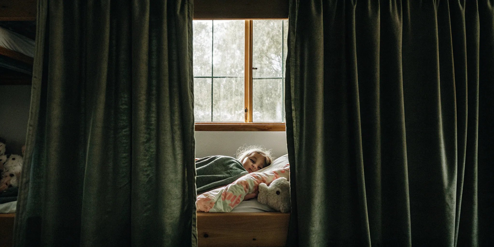 Child sleeping soundly under a weighted blanket.