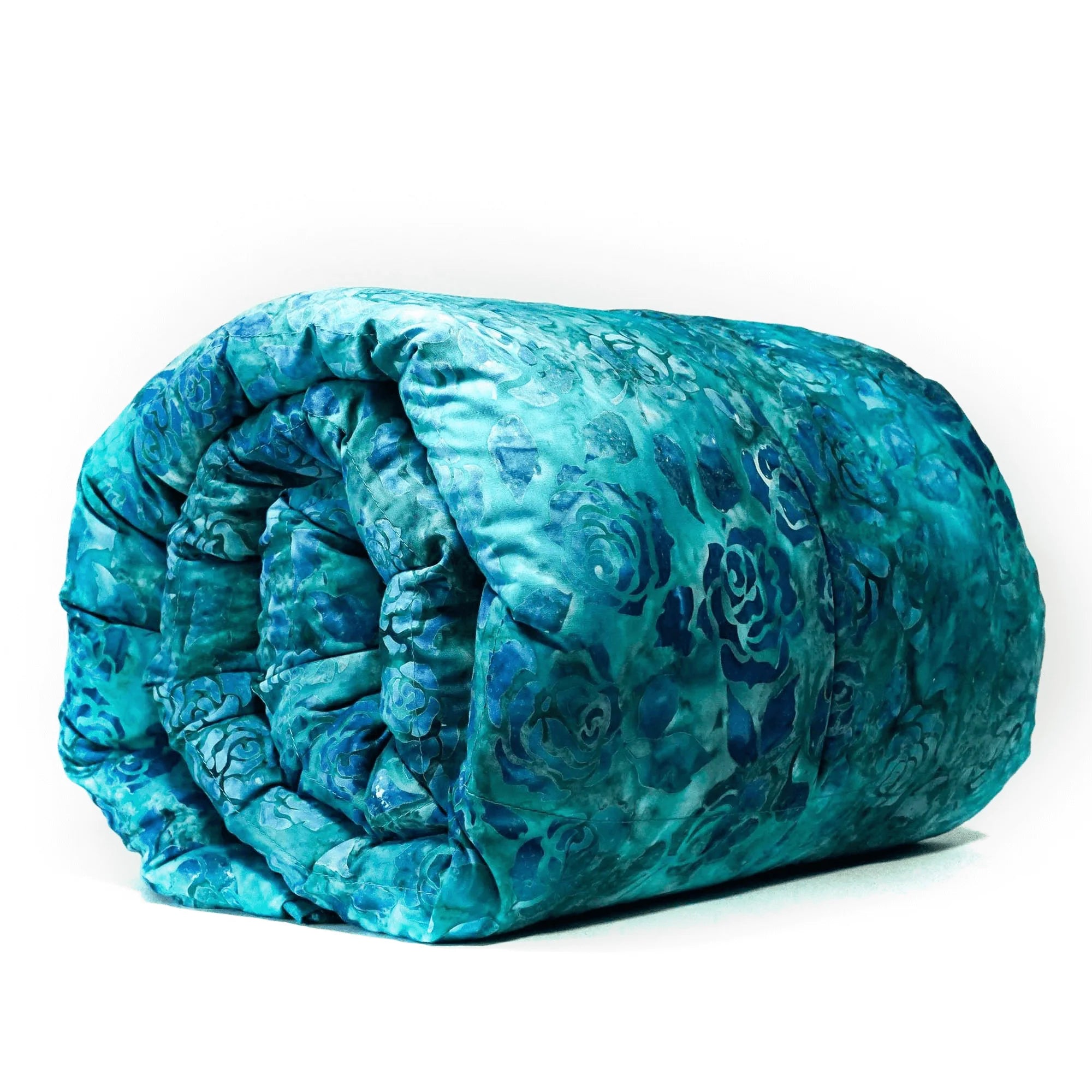 A rolled-up weighted blanket with a blue rose print over teal fabric.