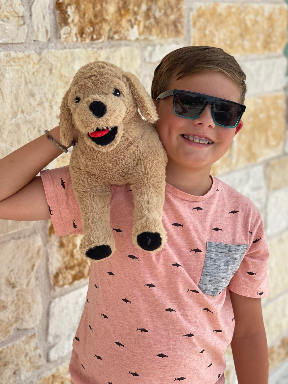 Little boy with his Leo the Pup is a weighted stuffed animal on his shoulder