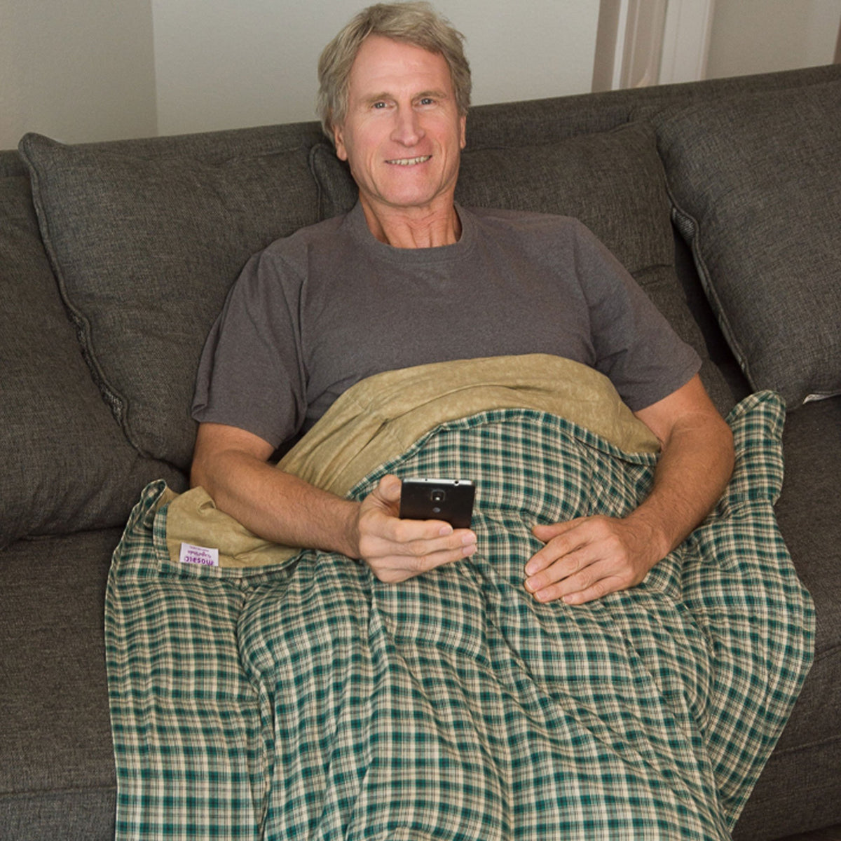 Man watches TV from under his Mosaic Weighted Blankets Green Khaki Plaid Cotton Weighted Blanket
