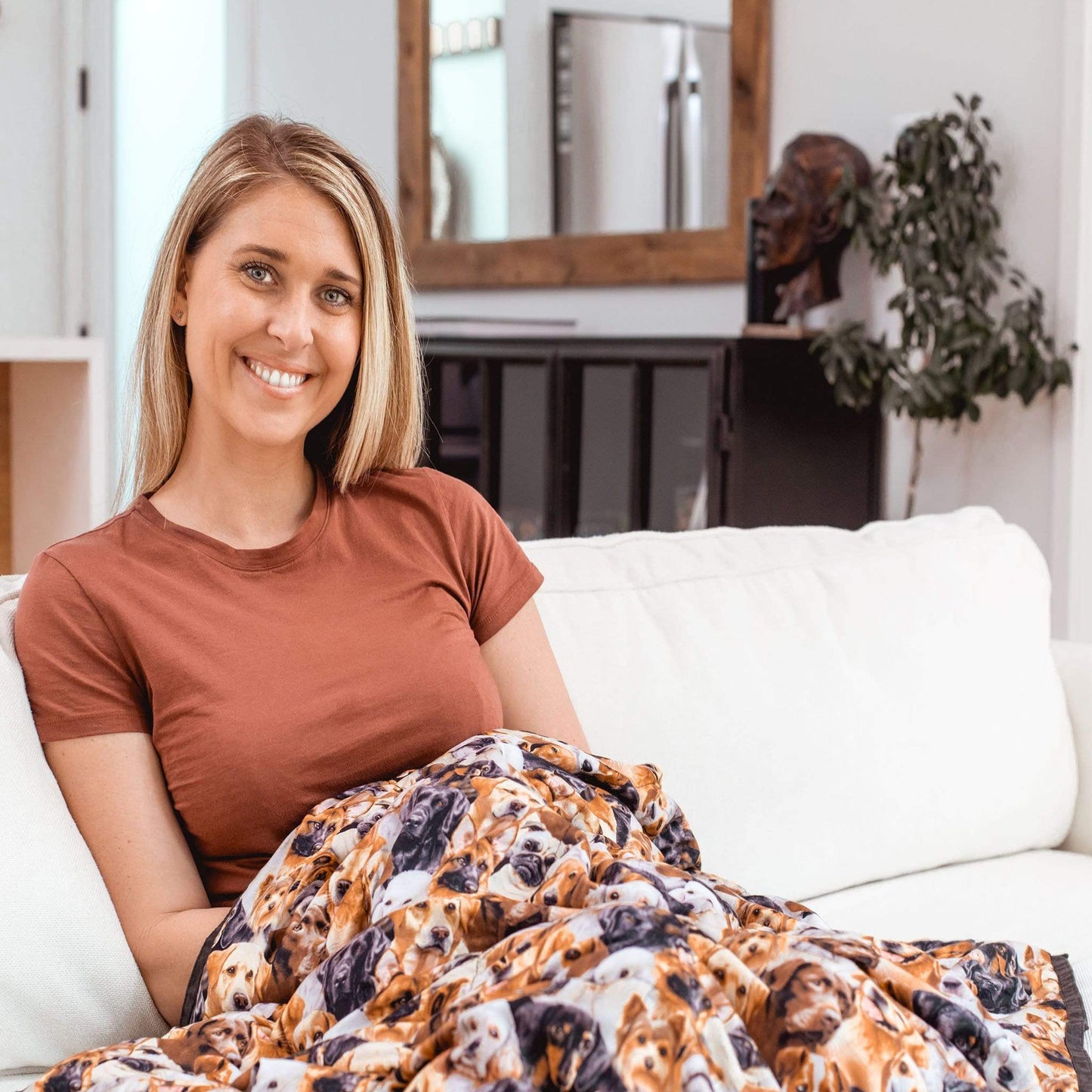 Woman under a Mosaic Weighted Blankets So Many Dogs Weighted Blanket on a couch