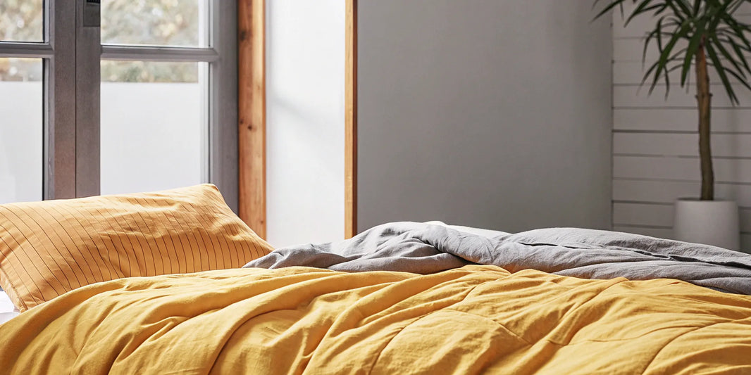 A calming organic cotton weighted blanket layered on a comfortable bed.