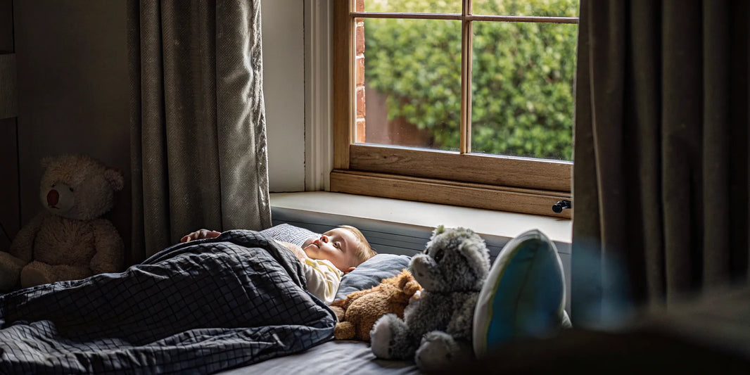 A toddler sleeping calmly under one of the best sensory blankets.