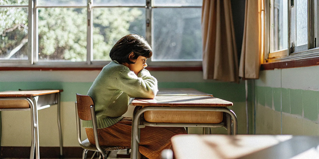 A student uses one of the best weighted lap pads at their classroom desk to help with focus.