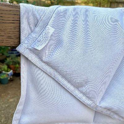 Close-up of a Mosaic Weighted Blanket draped over a wooden rail, showing breathable fabric texture and stitched weight compartments, illustrating quality construction for choosing the right blanket weight.