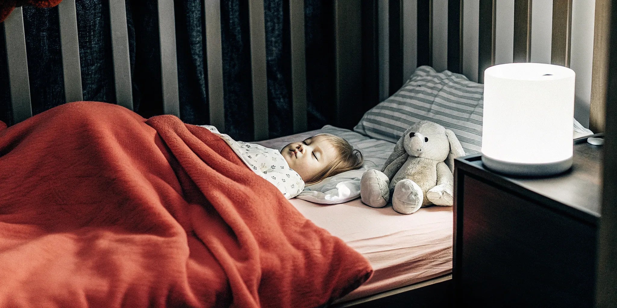 A toddler sleeping in a crib, prompting the question of are weighted blankets safe for toddlers.