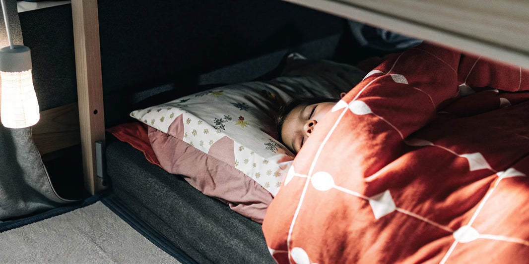 A child with anxiety sleeps peacefully under a calming blanket.
