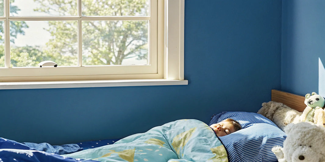 A child sleeping peacefully under a calming blanket for children.