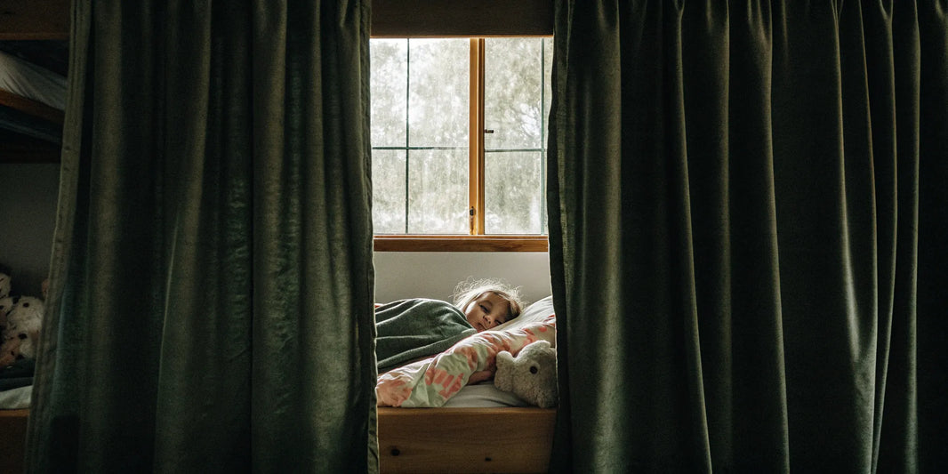 Child sleeping soundly under a weighted blanket.