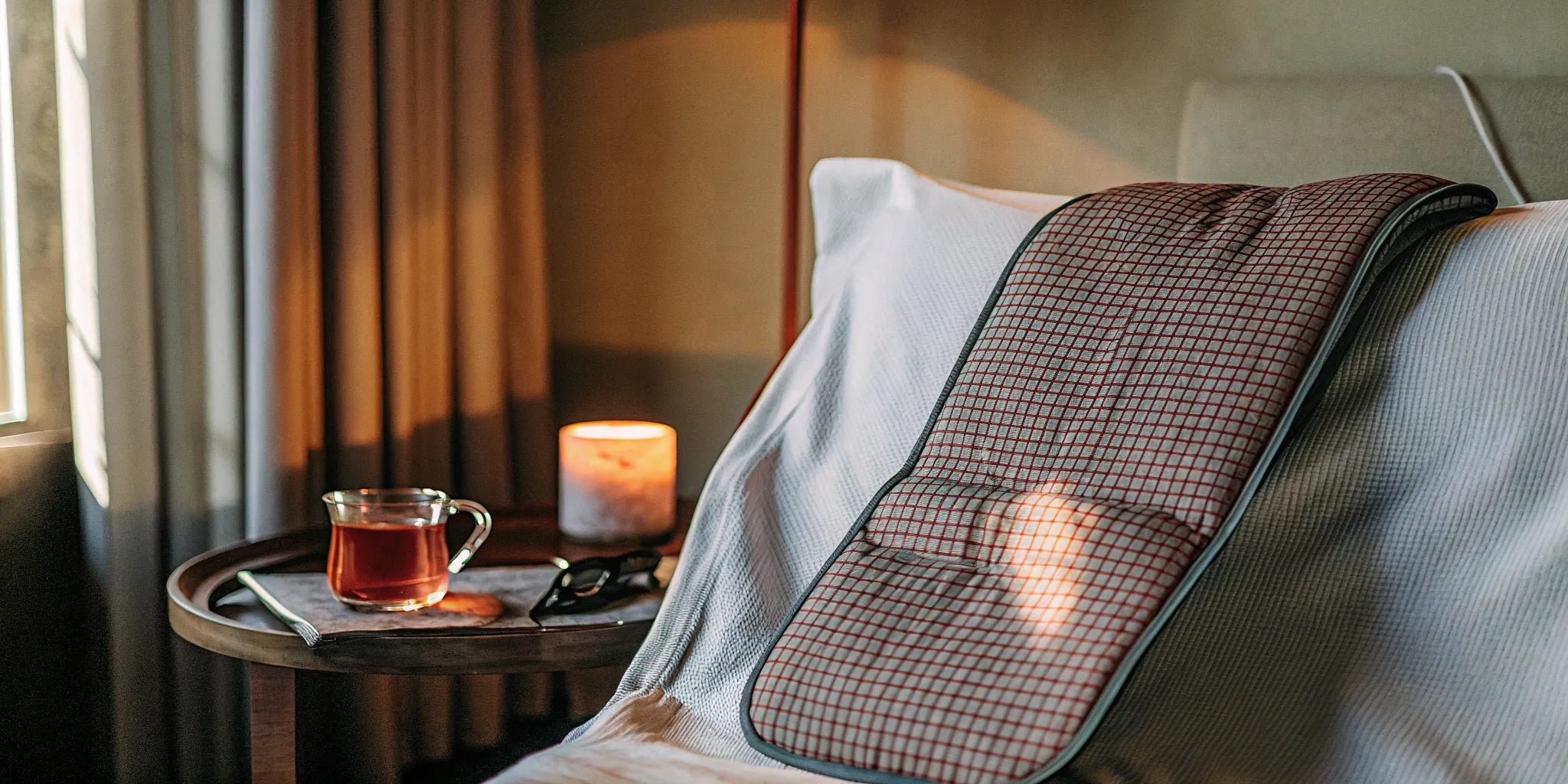 A weighted shoulder wrap for adults resting on a bed, providing deep pressure comfort.