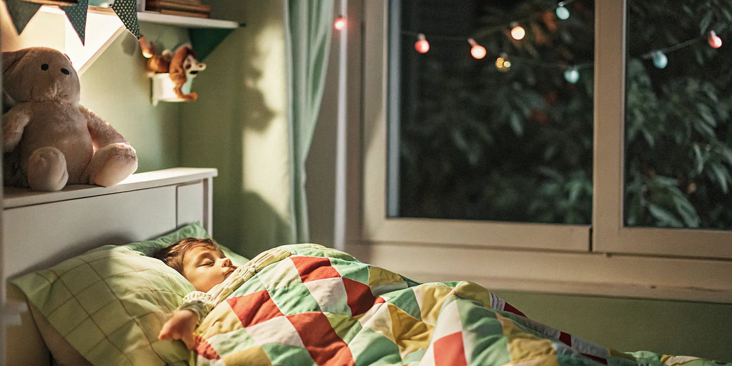 A child introduced to a calming blanket sleeps securely in their bed.