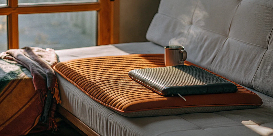 A weighted lap pad for anxiety resting on a couch.