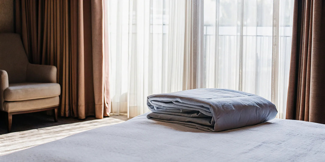A 20 lb weighted blanket folded on a bed to help decide if the weight is too heavy.