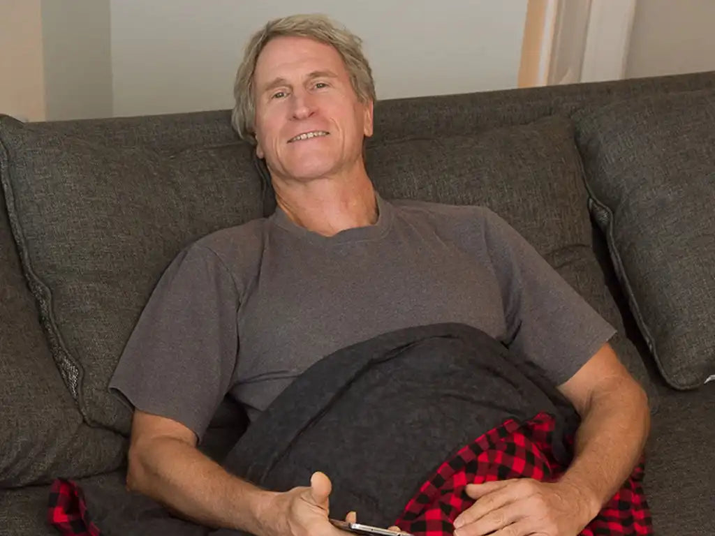 older gentleman resting comfortably under an mosaic weighted blanket on his lap