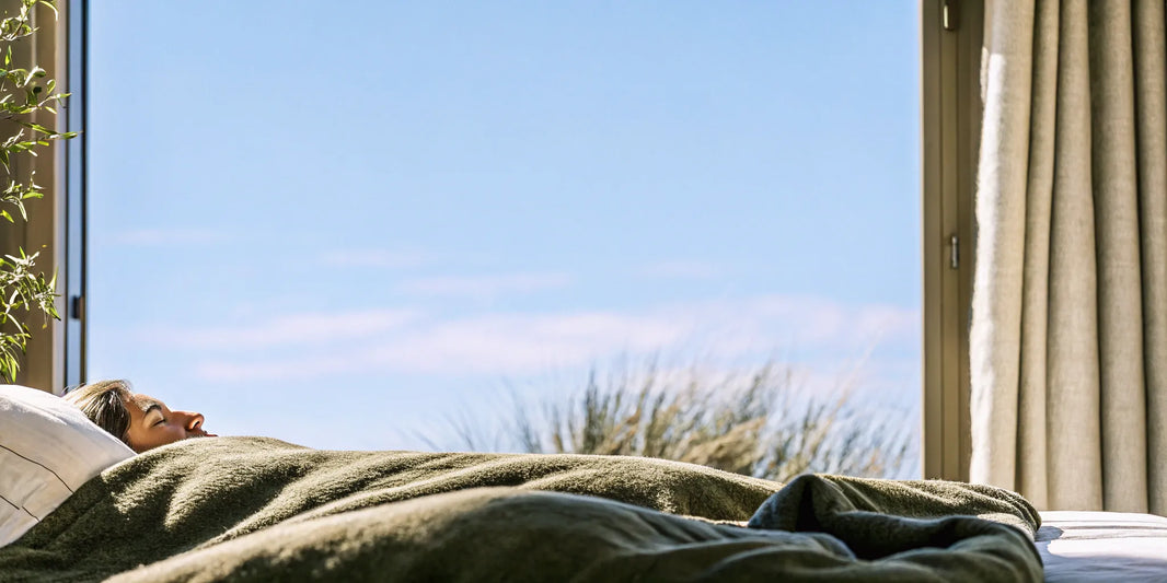 Person sleeping under a heavy blanket for deep, calming sleep.