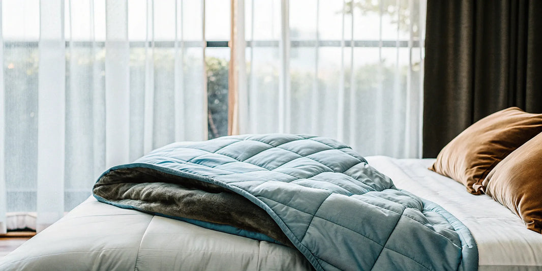 A custom weighted blanket with personal pictures draped over a bed.