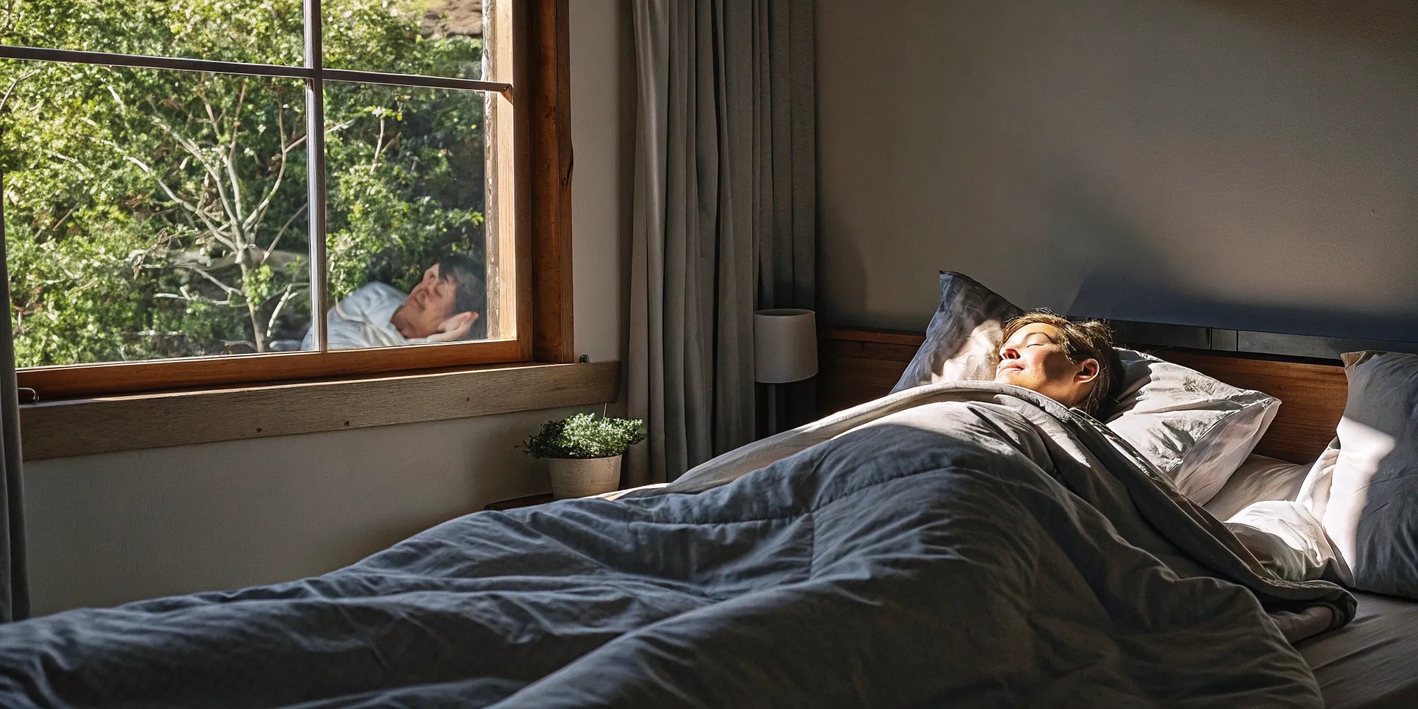 Woman sleeping peacefully under a weighted blanket on a king size bed.