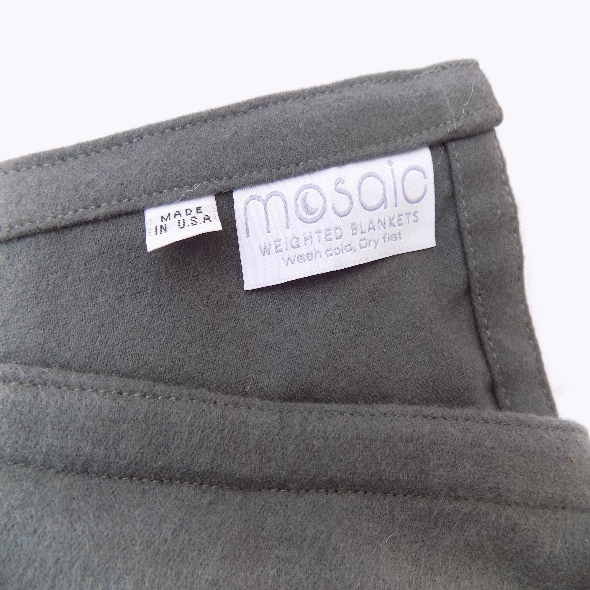 grey flannel weighted blanket and its mosaic tag.