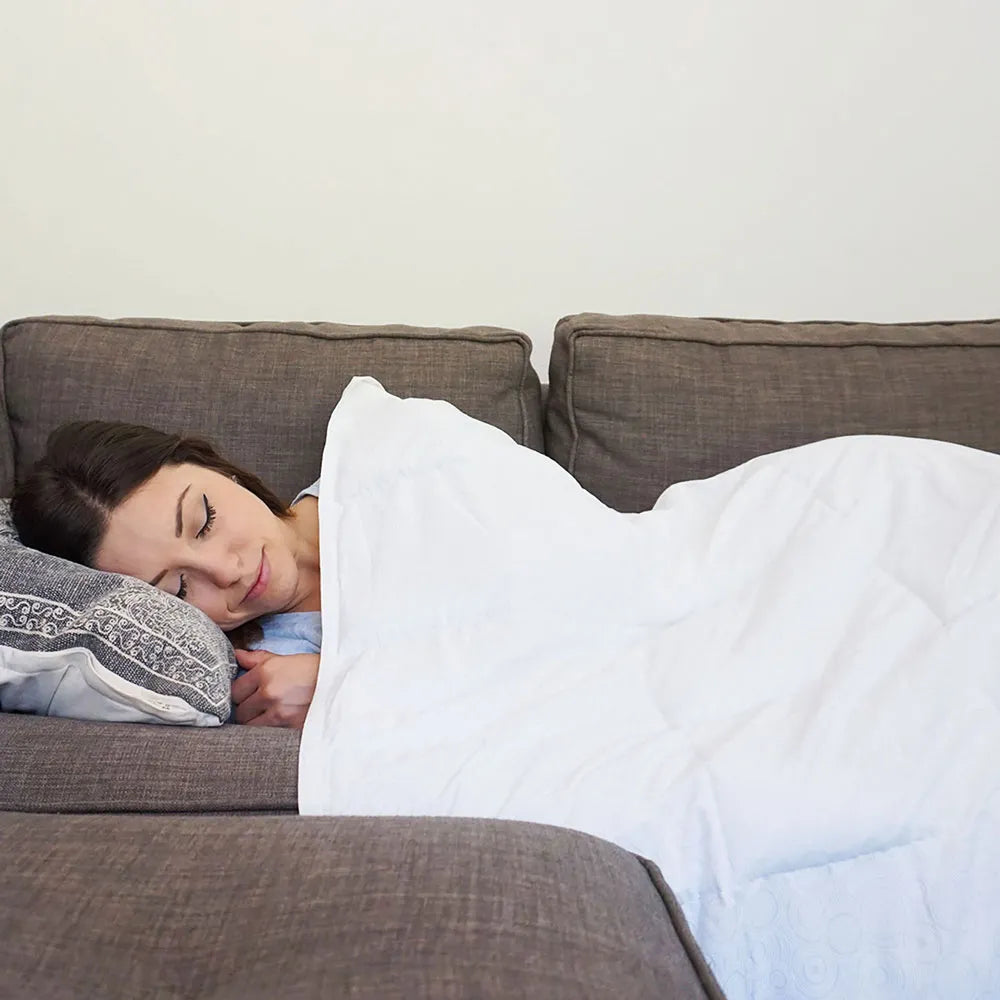 Woman resting on a couch under a white Coolmax cooling weighted 