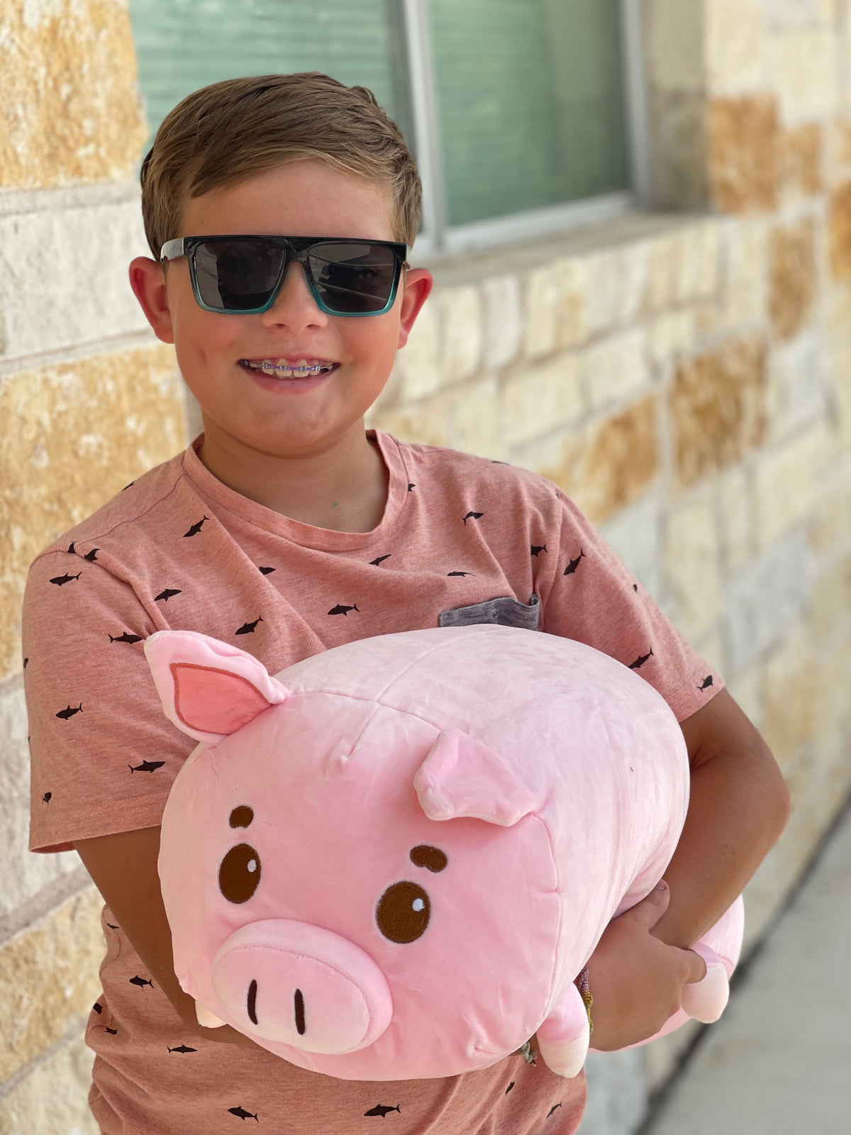Boy holding his Mel the Pig is a weighted stuffed animal