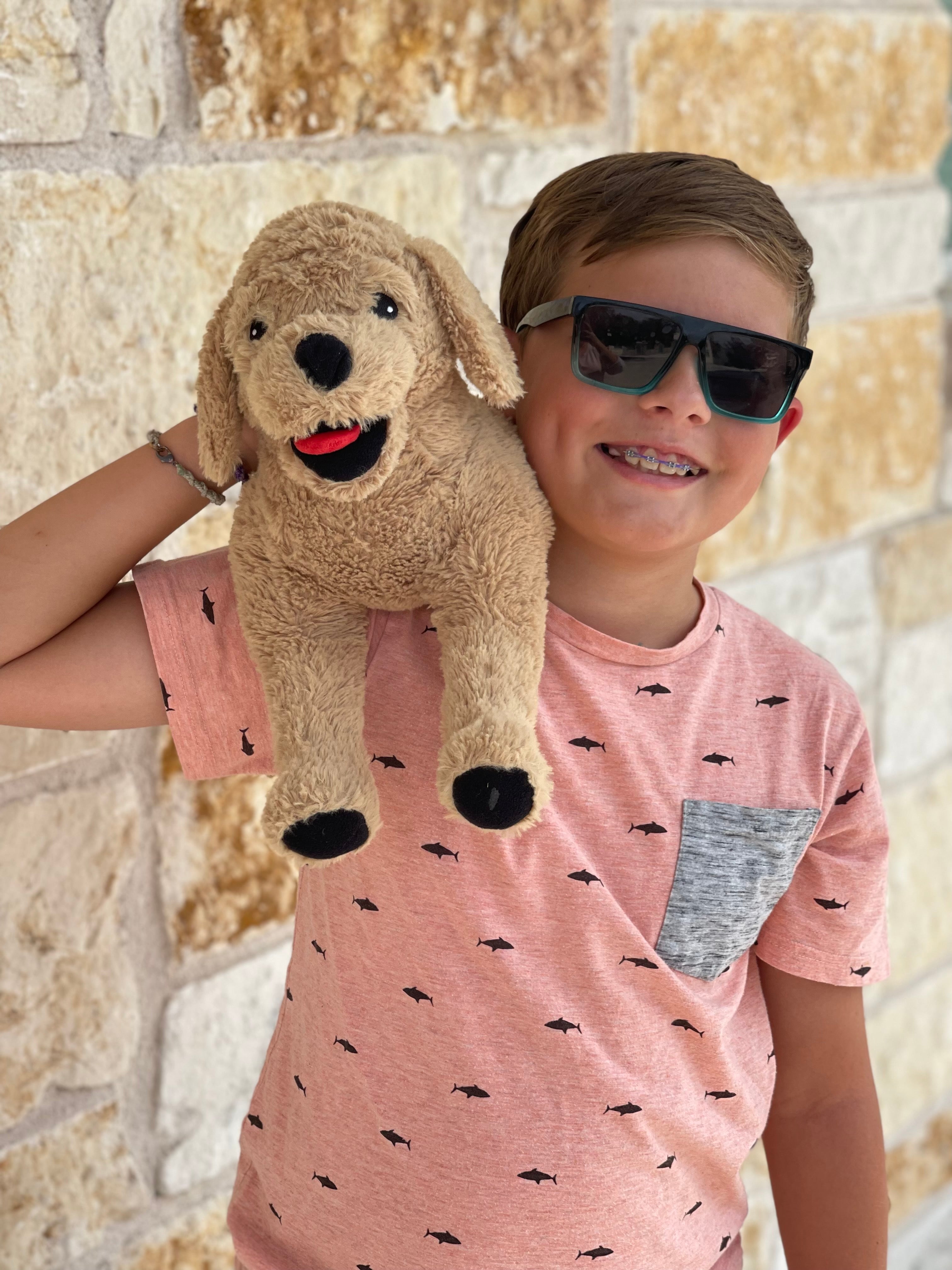 Little boy with his Leo the Pup is a weighted stuffed animal on his shoulder
