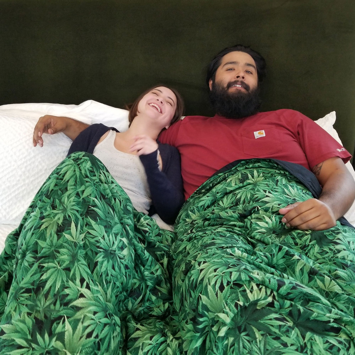 A couple snuggles under their CannaBliss Weighted Blanket in bed