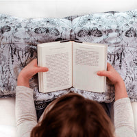 Girl reads while snuggled under her Mosaic Weighted Blankets Grab Bag Weighted Lap Pad