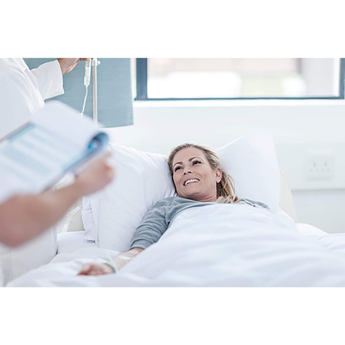 Hospital patient snuggled under her Hospital Grade Anti-Microbial Blankets with Cover