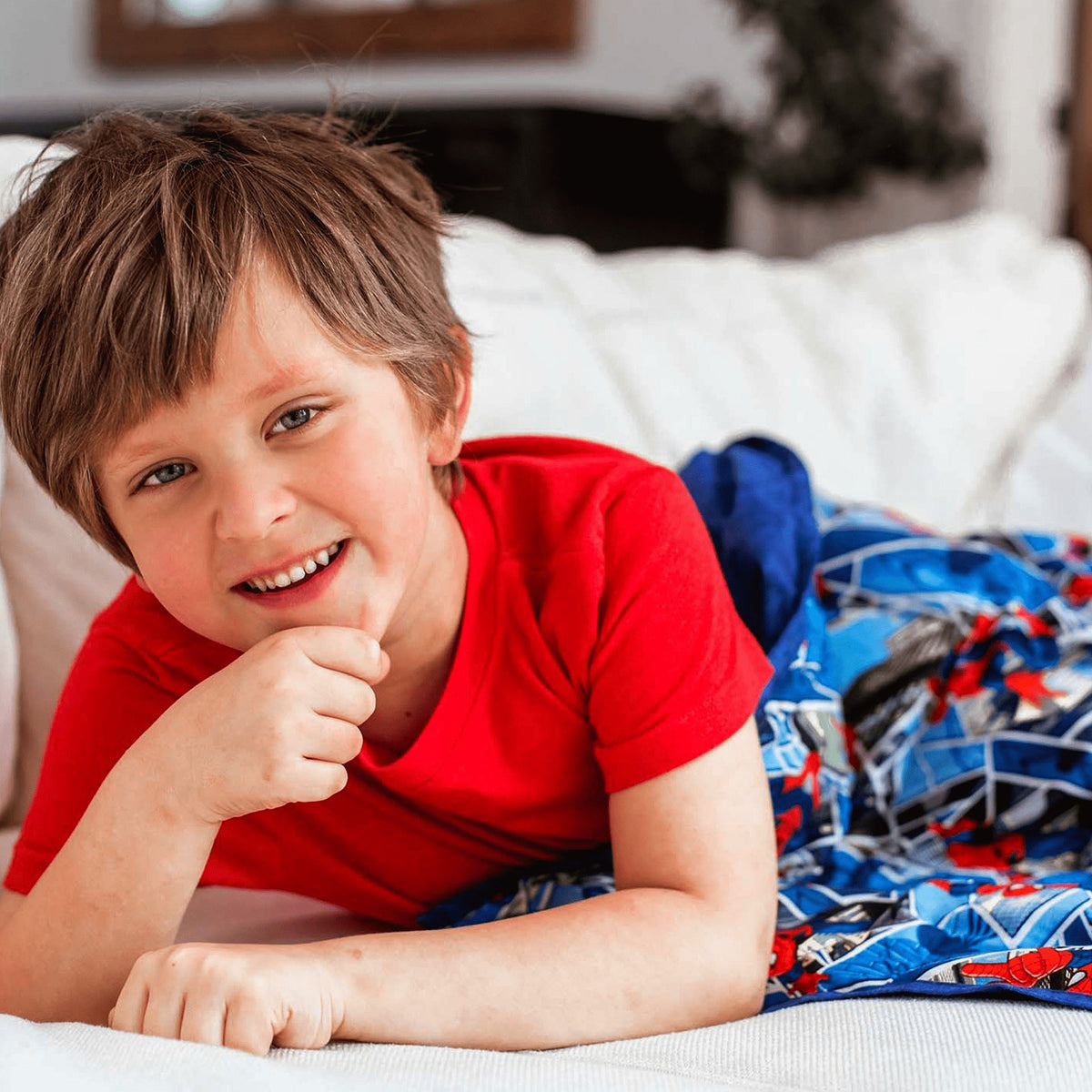 Little boy snuggled into his Mosaic Weighted Blankets Spider Man Weighted Blanket in bed